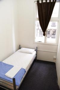 a bed in a room with a window at Maze Backpackers - Sydney in Sydney