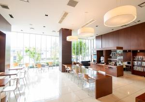 uma grande sala com mesas, cadeiras e janelas em Hotel day by day em Hamamatsu