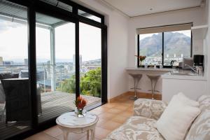sala de estar con sofá y mesa en Upperbloem Guesthouse and Apartments, en Ciudad del Cabo
