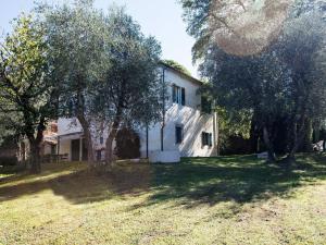 una casa blanca con árboles delante de ella en Belvilla by OYO Casa Prati, en Ghizzano