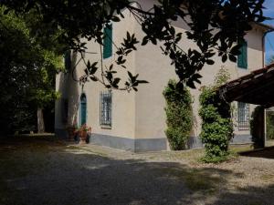 un edificio con ventanas con contraventanas verdes y un árbol en Belvilla by OYO Casa Prati, en Ghizzano