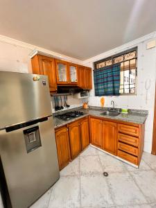 uma cozinha com armários de madeira e um frigorífico de aço inoxidável em El peñón del rodadero em Santa Marta