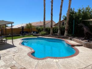 a swimming pool in a yard with palm trees at Gorgeous Henderson Home with Pool! in Las Vegas