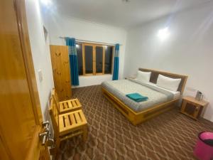 a small bedroom with a bed and a window at Otsal guest house nubra in Deskit