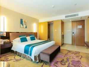 a large bedroom with a large bed with blue pillows at Guangzhou Easun Guotai hotel in Guangzhou