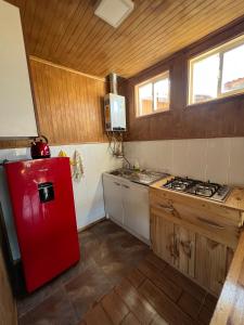 een keuken met een rode koelkast en een fornuis bij Siempre Verde in Puerto Tranquilo