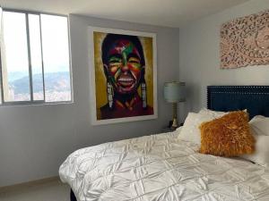 un dormitorio con una gran pintura de un payaso en New Lovely 3 bedroom condo with an AWESOME view!, en Bello