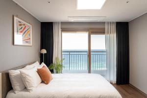 a bedroom with a bed and a large window at Urbanstay Sokcho beach C in Sokcho