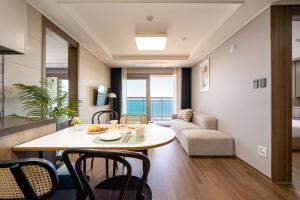 束草市的住宿－Urbanstay Sokcho beach C，客厅配有桌子和沙发