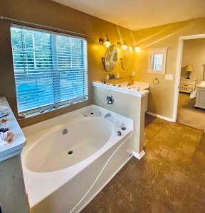 a large bathroom with a large tub and a sink at The Cozy Hidden Gem in Charleston