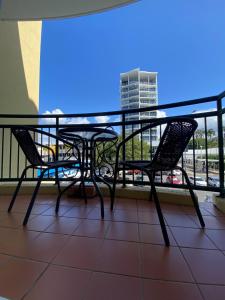 a patio area with chairs, tables, and umbrellas at Il Palazzo Holiday Apartments in Cairns