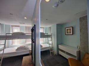 a room with two bunk beds and a mirror at U Street Capsule Hostel in Washington, D.C.