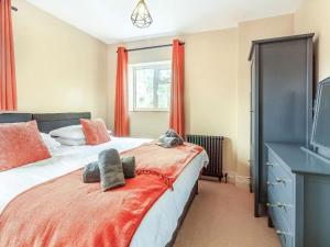 a bedroom with a bed and a window with red curtains at Ivet Lowe in Matlock