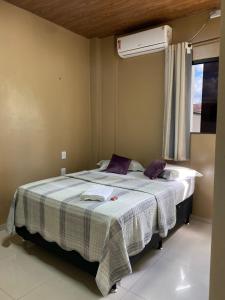 Schlafzimmer mit einem großen Bett und einem Fenster in der Unterkunft HOTEL LISBOA in Capanema