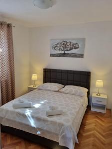Apartments Smilja - great location في سوبيتار: غرفة نوم بسرير كبير فيها مصباحين