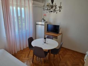 Apartments Smilja - great location في سوبيتار: غرفة طعام صغيرة مع طاولة وكراسي بيضاء