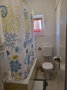 a bathroom with a toilet and a shower curtain at Apartments Smilja - great location in Supetar