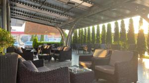 an outdoor patio with chairs and tables and areens at Hotel Emka in Tetovo