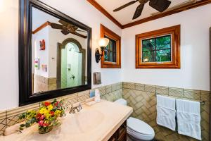 a bathroom with a sink and a toilet and a mirror at La Esquina (3 minutes from Beach, perfect for a family getaway) in Tamarindo