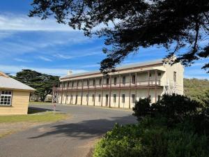 a large white building with a road in front of it at Cosy Back Beach Hideaway with Fire Pit. in Portsea