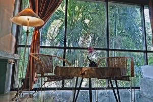 Zimmer mit einem Tisch und Stühlen sowie einem großen Fenster in der Unterkunft T Vintage in Bang Khla
