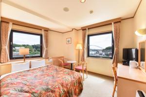 a hotel room with a bed and two windows at Iki Marina Hotel in Iki