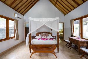 ein Schlafzimmer mit einem Himmelbett in der Unterkunft Mushroom Beach Bungalows in Nusa Lembongan