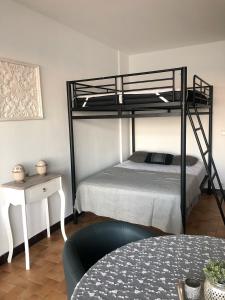 een slaapkamer met een stapelbed en een tafel bij Etoile de mer - Menton, Garavan in Menton
