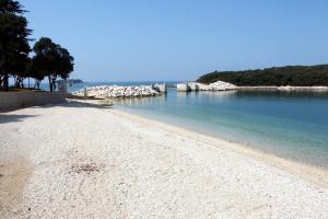 einen Sandstrand mit Felsen im Wasser in der Unterkunft Apartments and rooms with WiFi Vrsar, Porec - 3007 in Vrsar