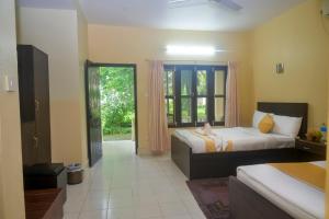 a bedroom with two beds and a large window at Hotel Rainforest in Sauraha