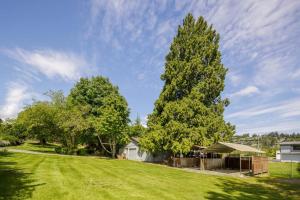 een tuin met twee grote bomen en een huis bij Gorgeous 7BDR 16 Guests Perfect For Your Family in Nanaimo