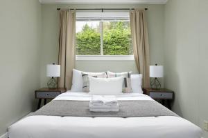 een slaapkamer met een groot wit bed en een raam bij Gorgeous 7BDR 16 Guests Perfect For Your Family in Nanaimo