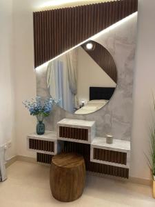 a bathroom with a mirror and a wooden stool at Ansam, Yas Island in Abu Dhabi