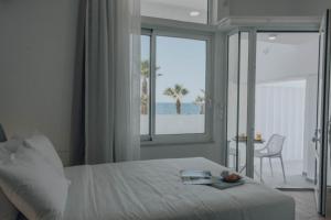 a bedroom with a bed with a view of the ocean at Suitenes Coast in Rethymno Town