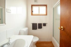 a bathroom with a sink and a toilet and a window at Wallaroo Beachfront Tourist Park in Wallaroo