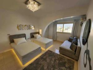 a living room with a couch and a bed and a chandelier at (AB By The River) 2BR 901 With Great View in Cairo