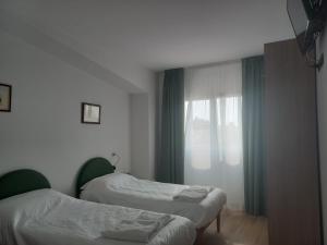 two beds in a room with a window at Gardafarm agriturismo in Verona