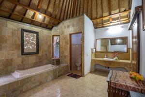 a large bathroom with a tub and a sink at Mushroom Beach Bungalows in Nusa Lembongan +86 photos