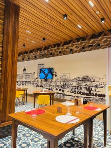 uma sala de jantar com uma mesa e um desenho na parede em Ginger Mumbai, Goregaon em Mumbai