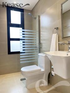 uma casa de banho com um WC, um lavatório e um espelho. em Kease Malqa A-6 Royal Touch XZ56 em Riyadh