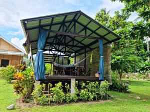 einen Pavillon mit Hängematte im Hof in der Unterkunft Bahandi Beach Lodge in Mambajao