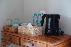 a coffee maker on a wooden table with bottles of water at Puri Bisma Ubud - 4 Bedroom PRIVATE VILLA - 10 min walking to Ubud Center in Ubud