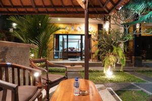 a patio with a wooden table and chairs at Puri Bisma Ubud - 4 Bedroom PRIVATE VILLA - 10 min walking to Ubud Center in Ubud