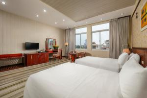 a hotel room with two beds and a television at Hoa Dao Hotel in Hanoi