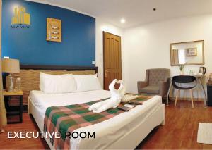 una habitación de hotel con una cama con un animal de peluche. en The New View by Ecotel, en Iloilo City