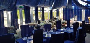 een kamer met blauwe tafels, stoelen en ramen bij Shiralee bed and breakfast in Salisbury