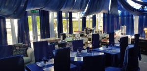 a room with blue tables and chairs and windows at Shiralee bed and breakfast in Salisbury