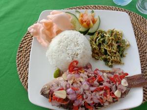 un plato de comida con arroz y verduras en una mesa en Batur Water Park Villa en Bangli