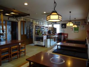 a coffee shop with tables and a counter in a room at Nagomi-tei in Hakuba