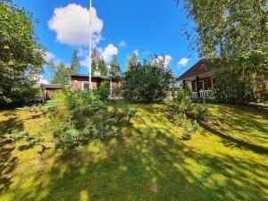 een huis op een heuvel met een grasveld bij Villa Onia - sauna, palju ja iso yksityinen piha in Lappers
